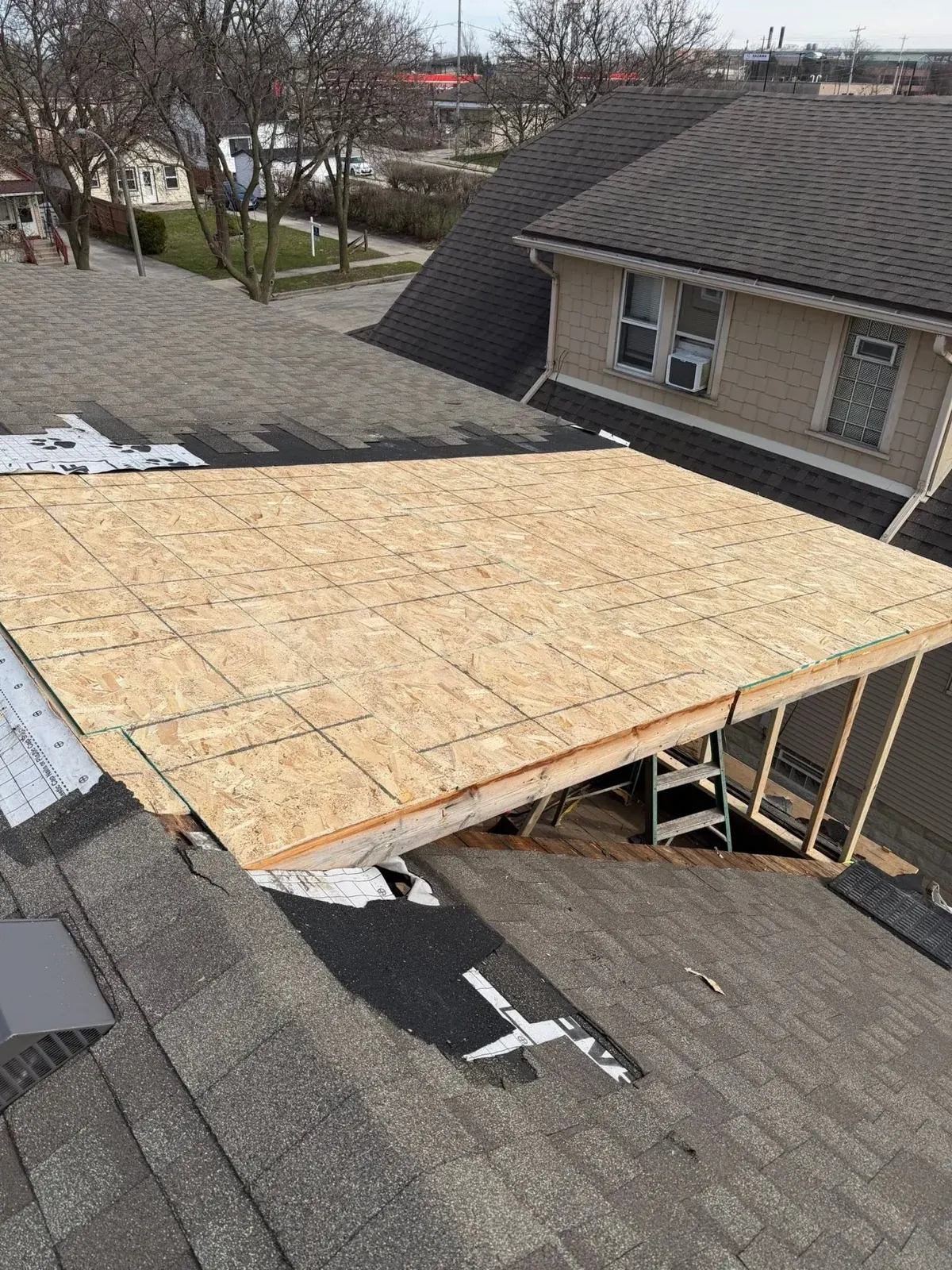 Roof framing under construction with OSB sheathing and exposed trusses on residential home